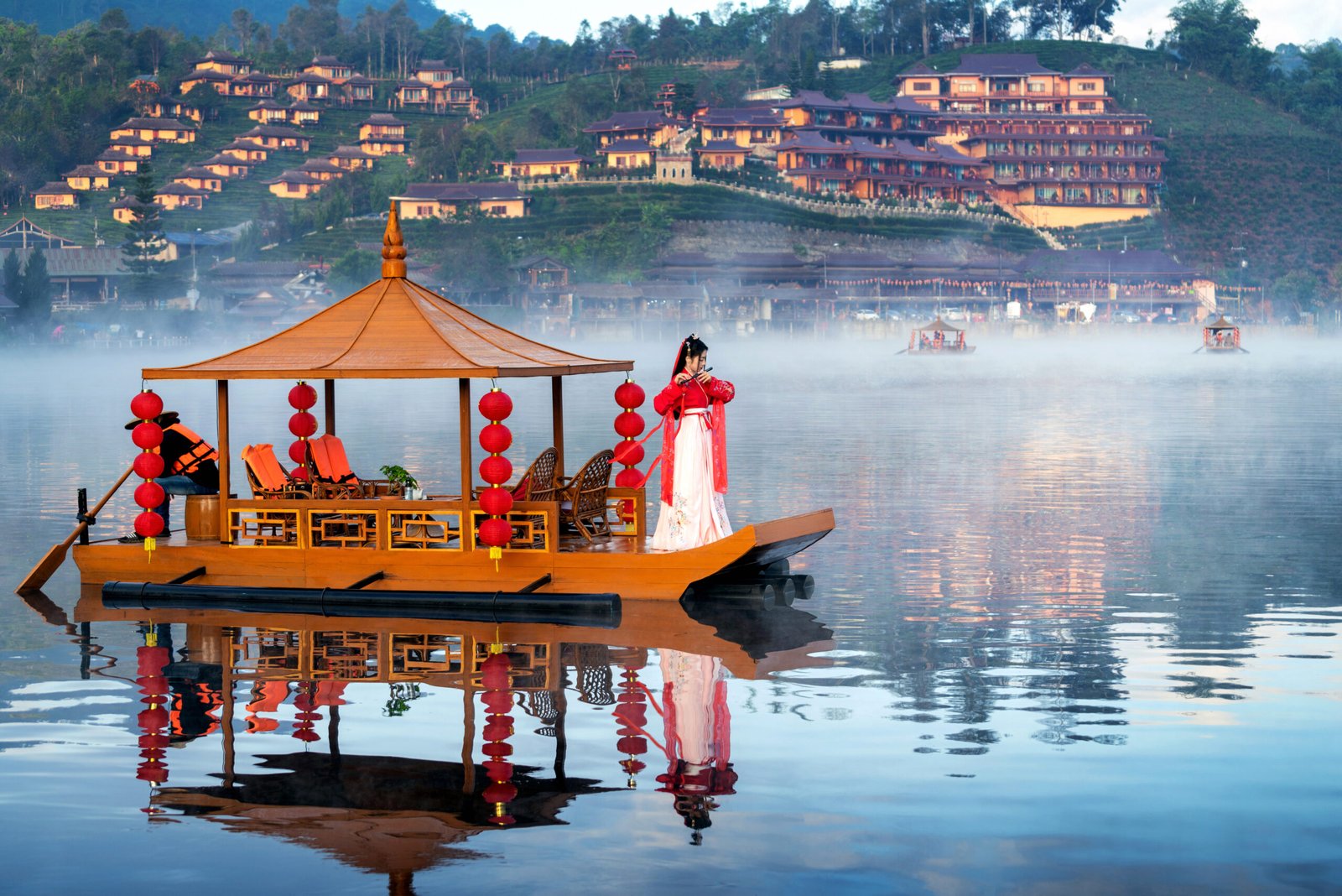 Asian woman wearing chinese traditional dress on a boat at Ban Rak Thai village, Mae hong son province.